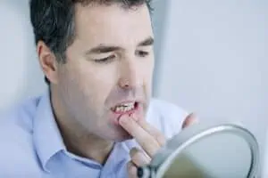 man examines his gums